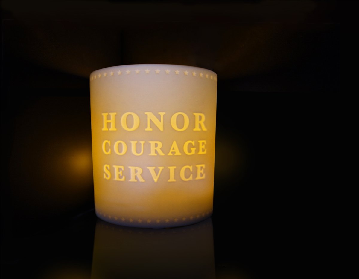 White votive tealight candle holder with words "Honor Courage Service" and border of stars along top and bottom.